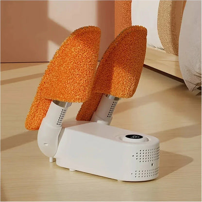White LivinH Portable Shoe Dryer used for drying with orange textured slippers on a wooden floor.